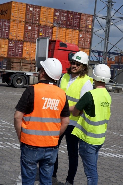 Zespół Elgreen i wykonawcy podczas ustaleń na placu w Porcie Gdynia, w tle kontenery i nabrzeże