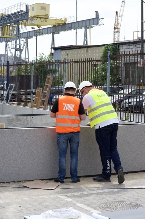 Prace przy prefabrykowanych elementach fundamentu stacji, w tle kontenery Portu Gdynia